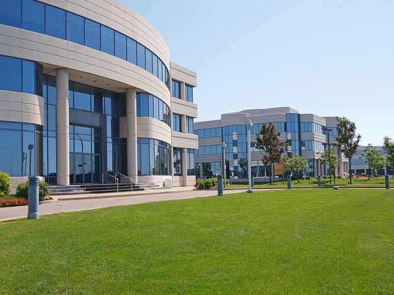 a large green field in front of a building