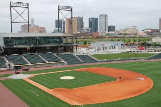 a group of people sitting around a baseball field