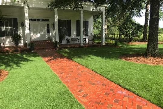 a large lawn in front of a brick building